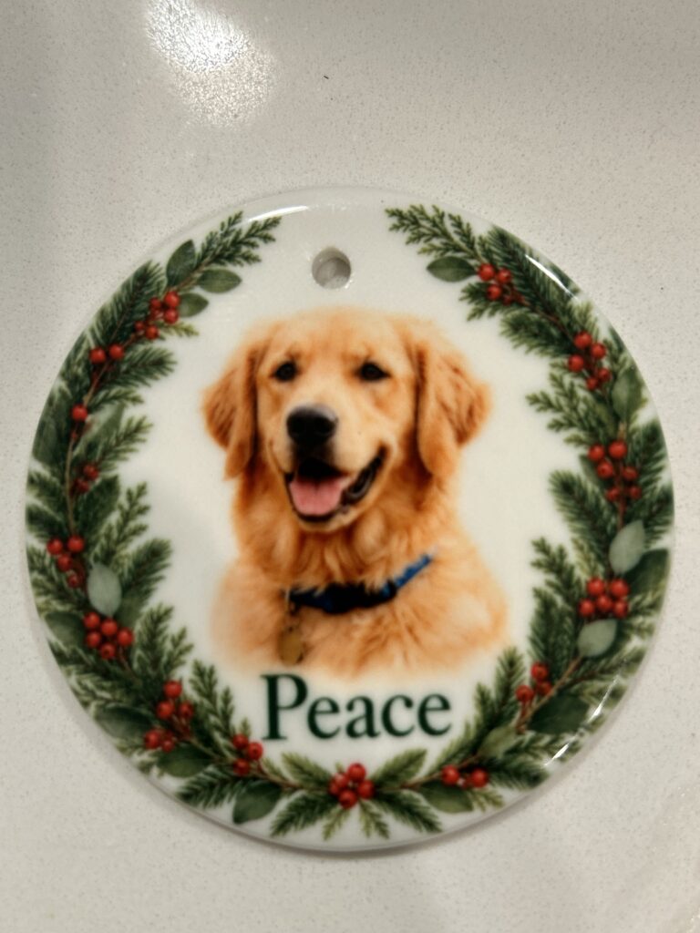 Real sample: personalized ceramic ornament with golden retriever photo, the name 'Peace', and holly wreath border